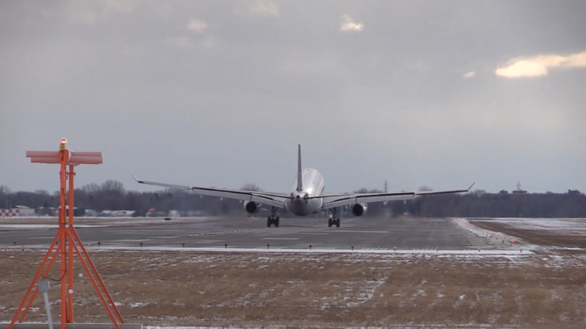A commercial airplane lands on a runway, reflecting the role of quality standards in aviation transport safety