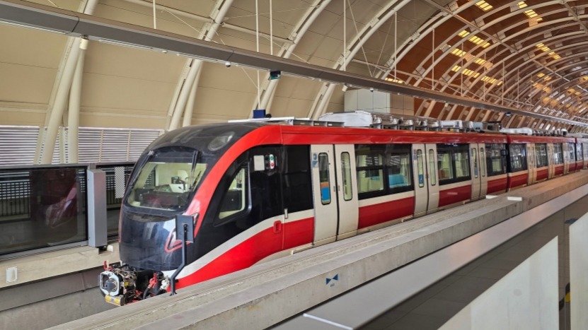 A modern red and white train stands at a station platform, highlighting the importance of quality standards in rail and transit safety