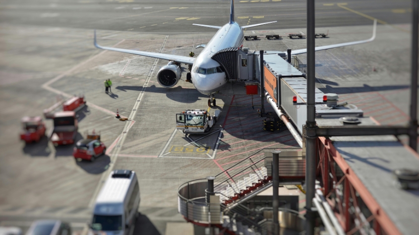 An airplane connected to a jet bridge during ground operations illustrates structured planning for transport leaders