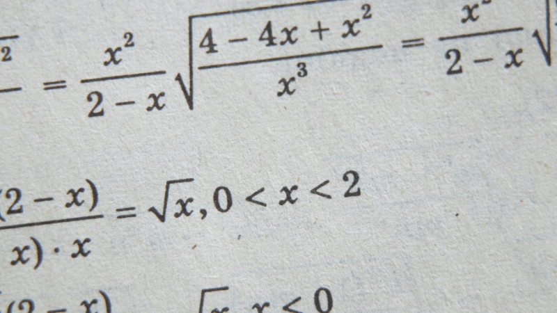 A close-up of algebraic expressions and constraints, showing careful execution in math and physics work
