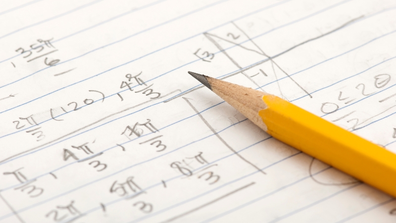 A sharpened pencil rests beside neatly written math steps, showing controlled problem solving