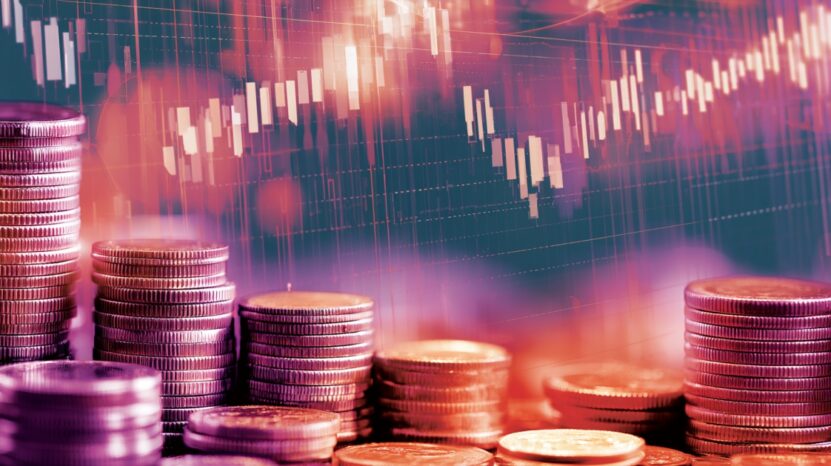 Stacks of coins with stock market charts illustrating investment education and financial growth