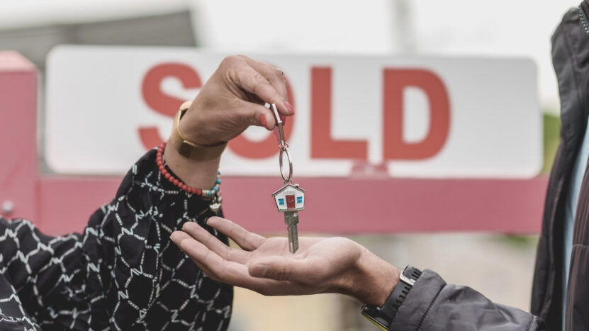 Handing over house keys to a new homeowner after a property sale.