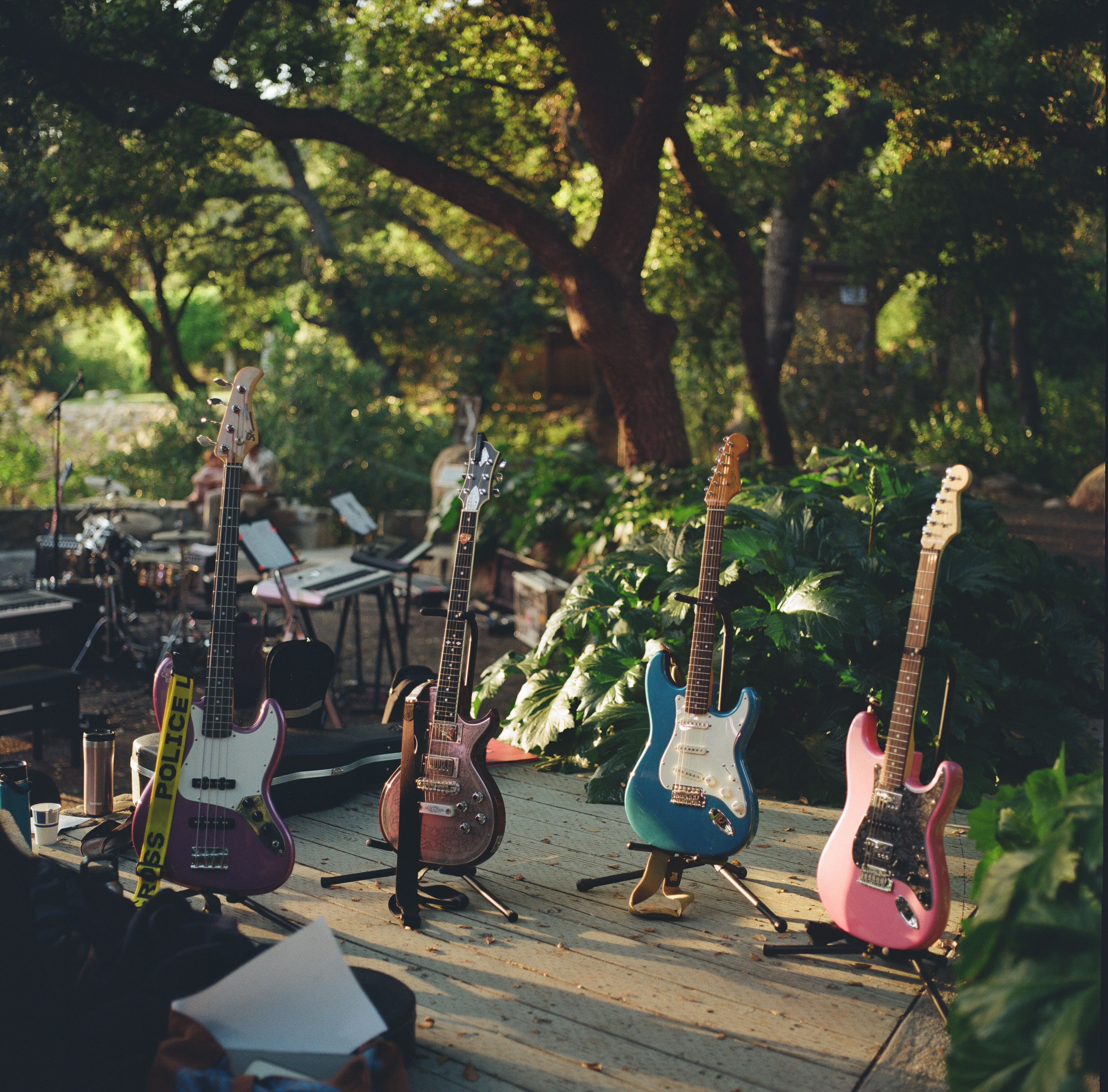 Row of colorful electric guitars on an outdoor stage ready for a summer music festival