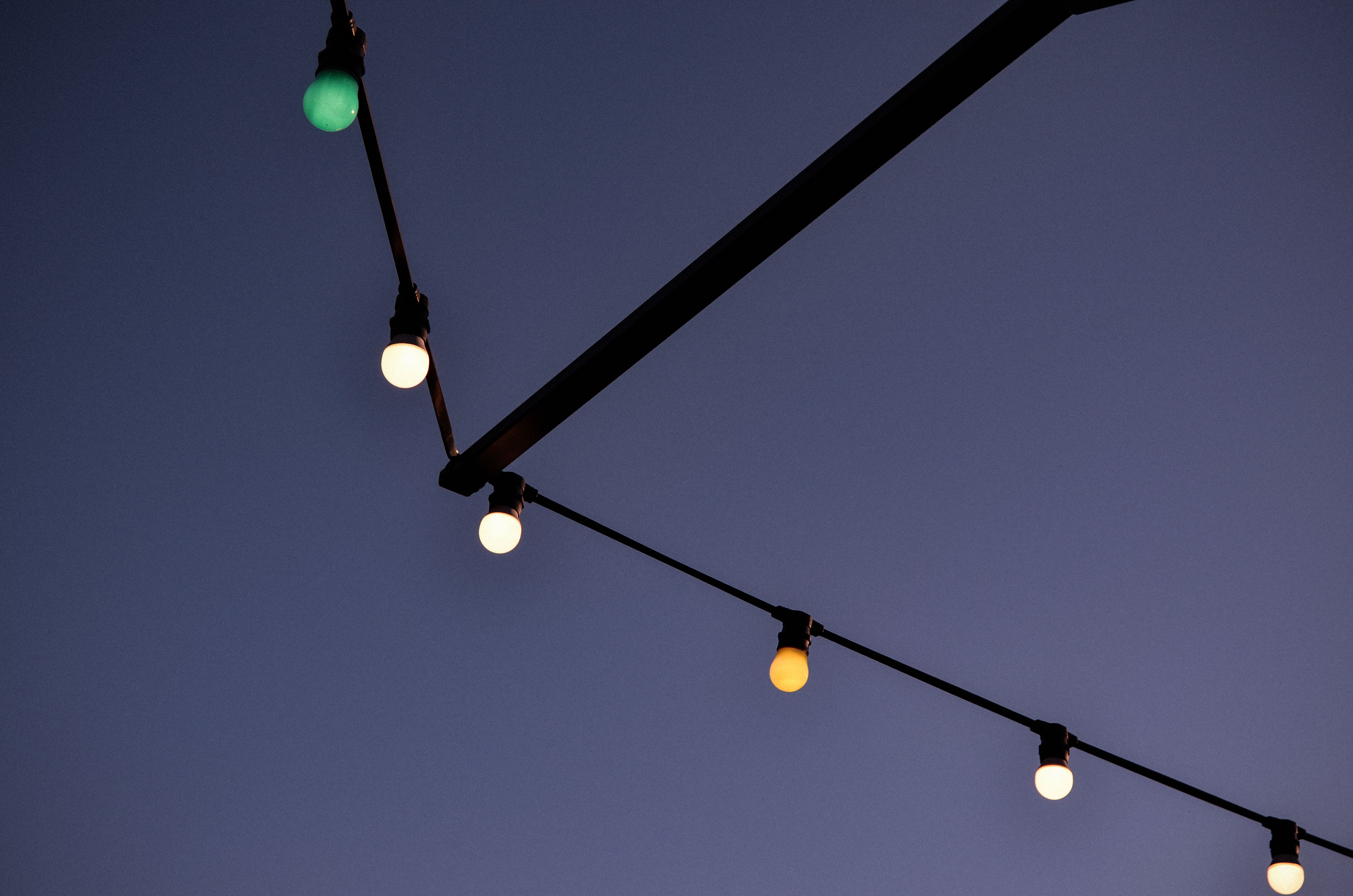 String lights hanging in a dark evening sky creating a backyard ambiance